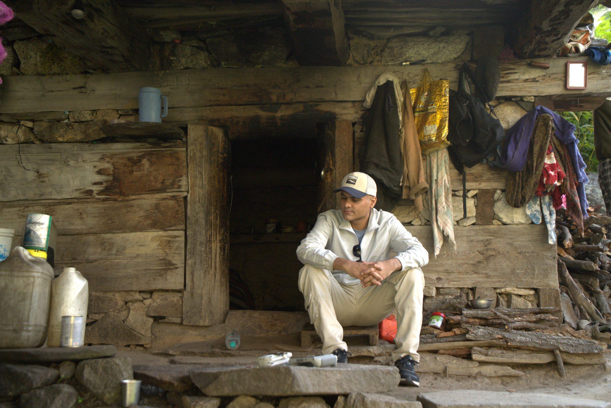 A shepherd sitting in the doorway of his timber hut