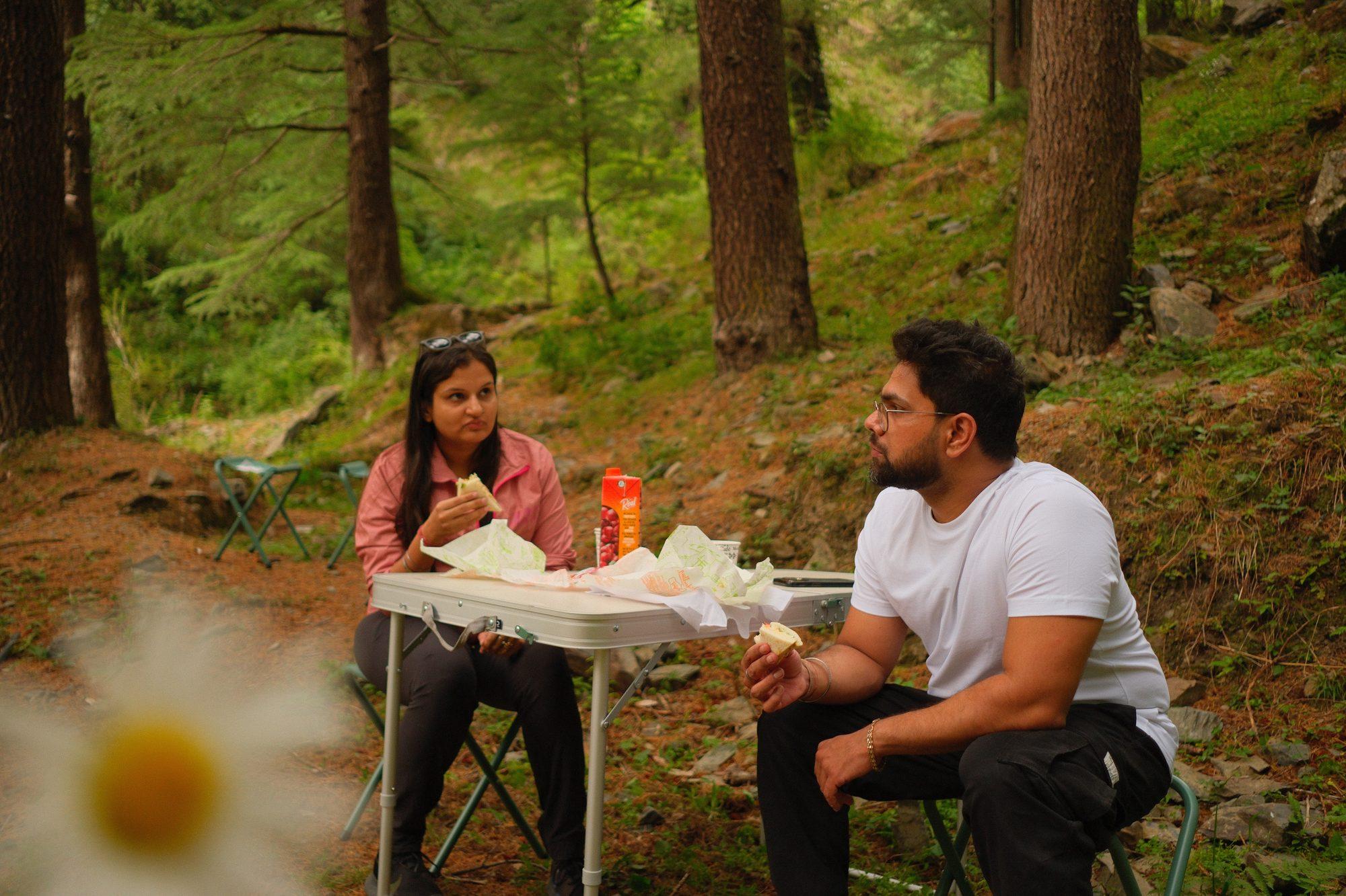 Two riders stopped for a roadside table in the deodars