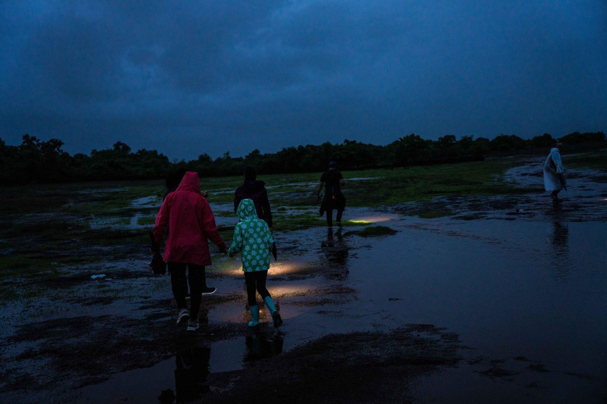 Walkers crossing the wet plateau at dusk