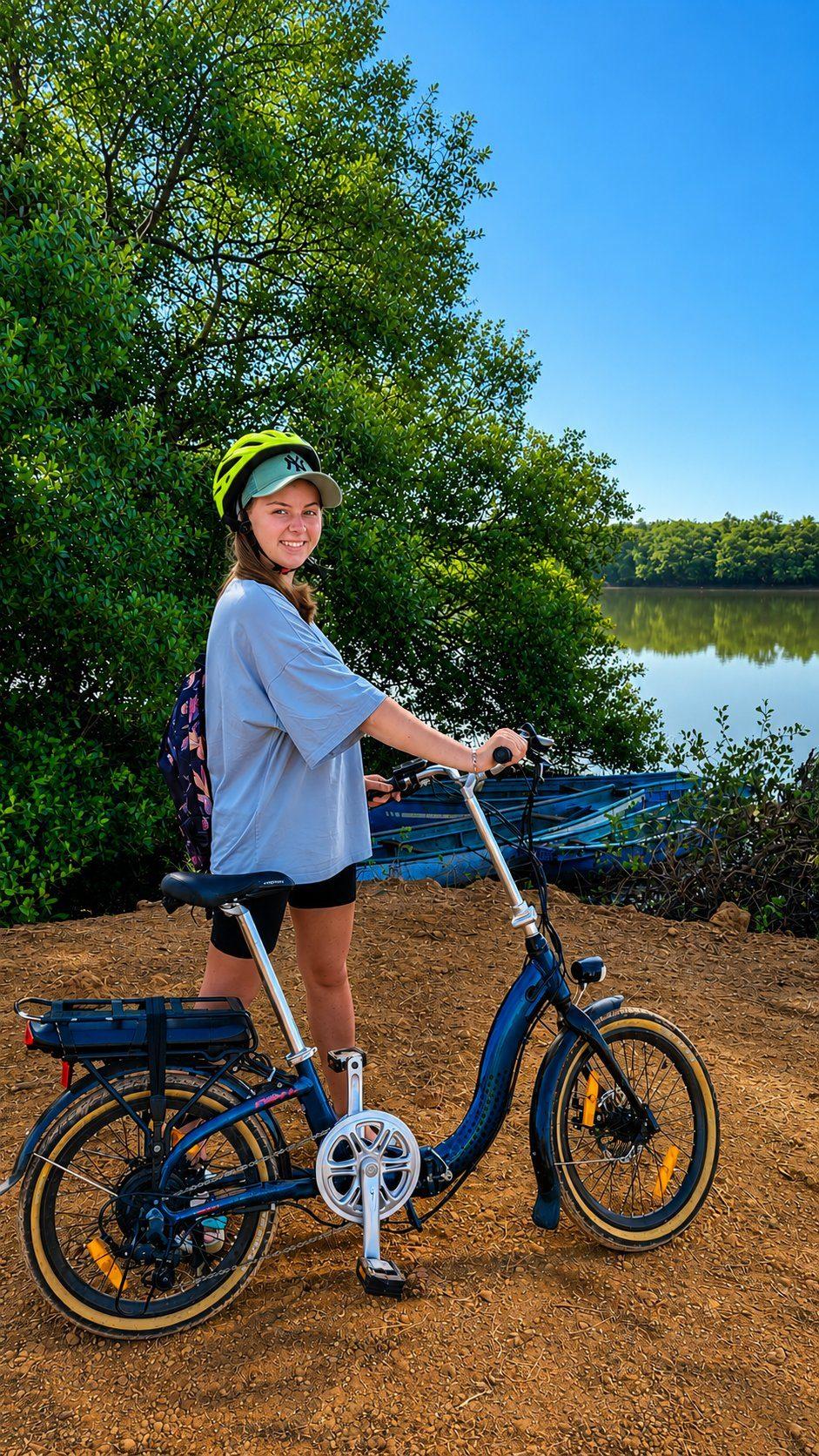 A rider with a folding e-bike beside the mangroves
