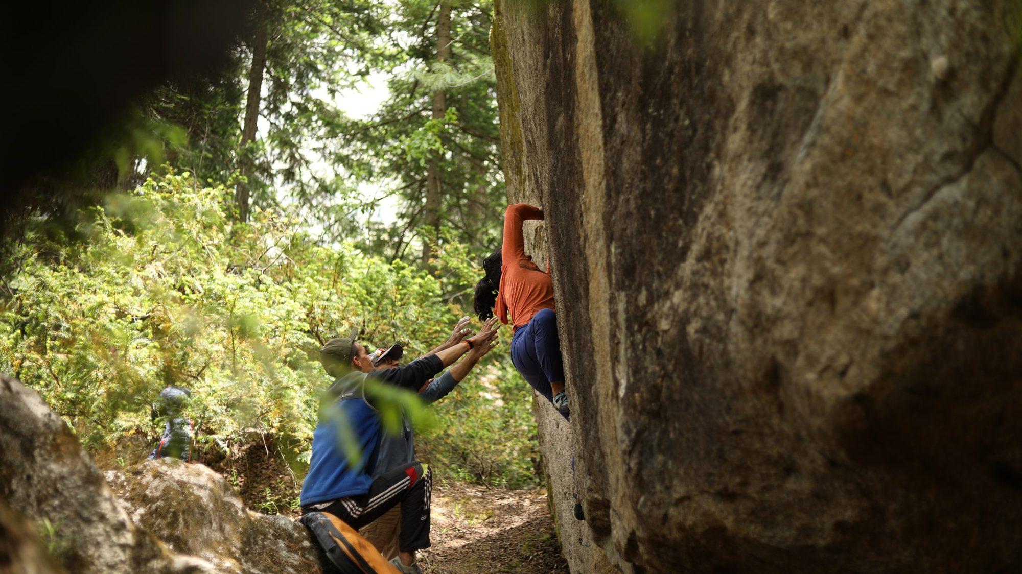 A climber on the overhang with a spotter below