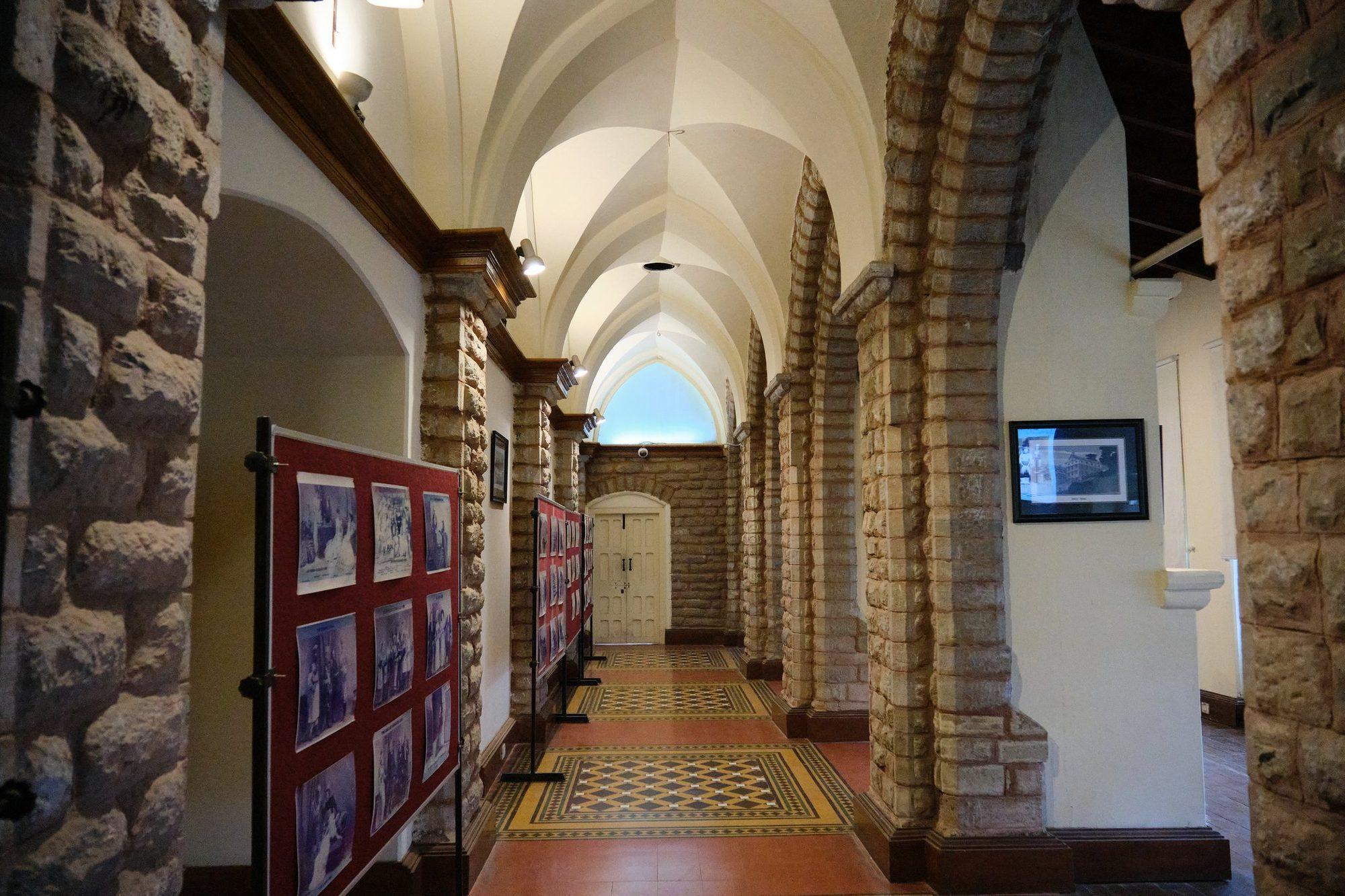 The stone-arched corridor hung with framed photographs