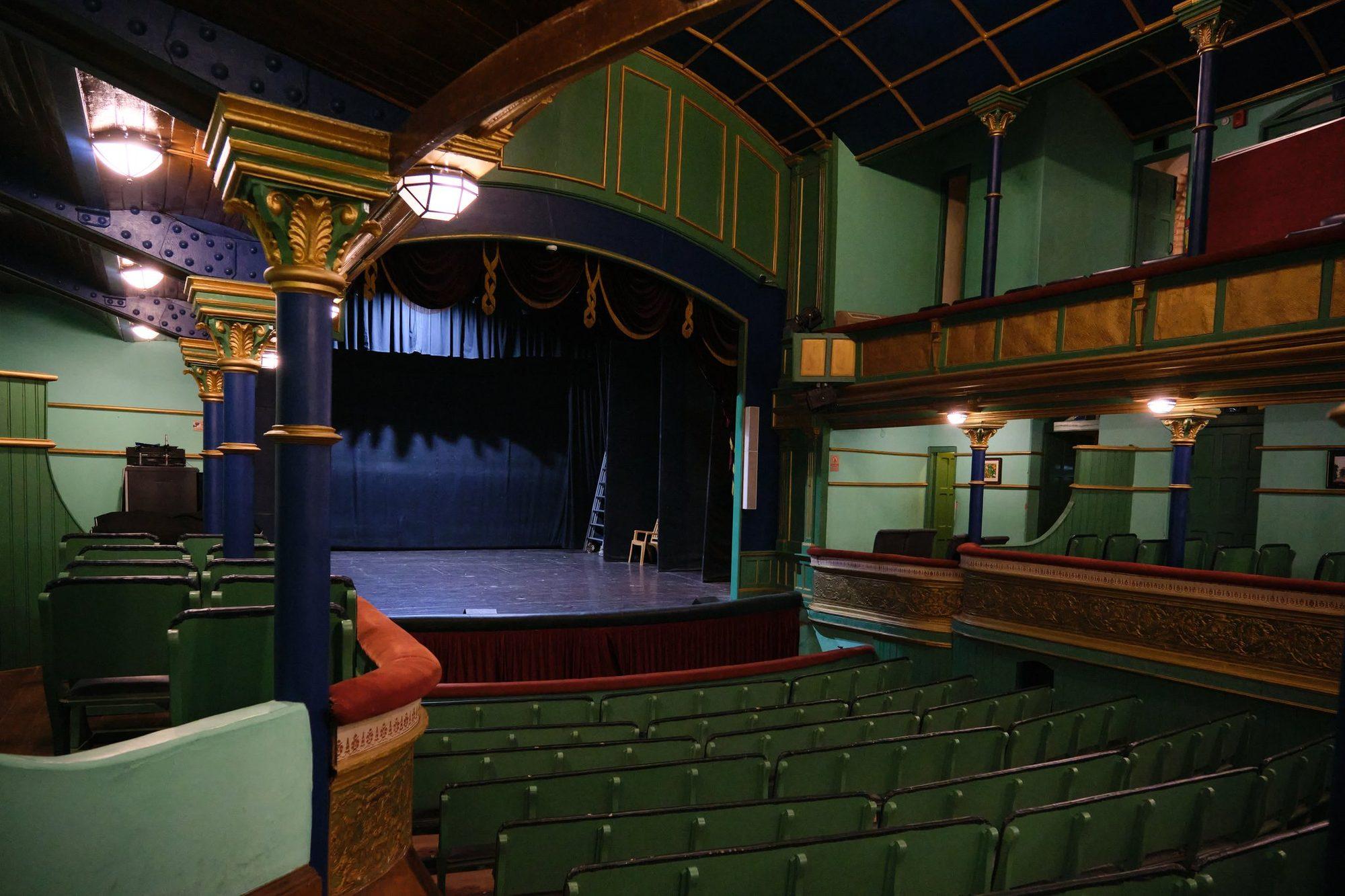 The tiered green seating of the auditorium from the side