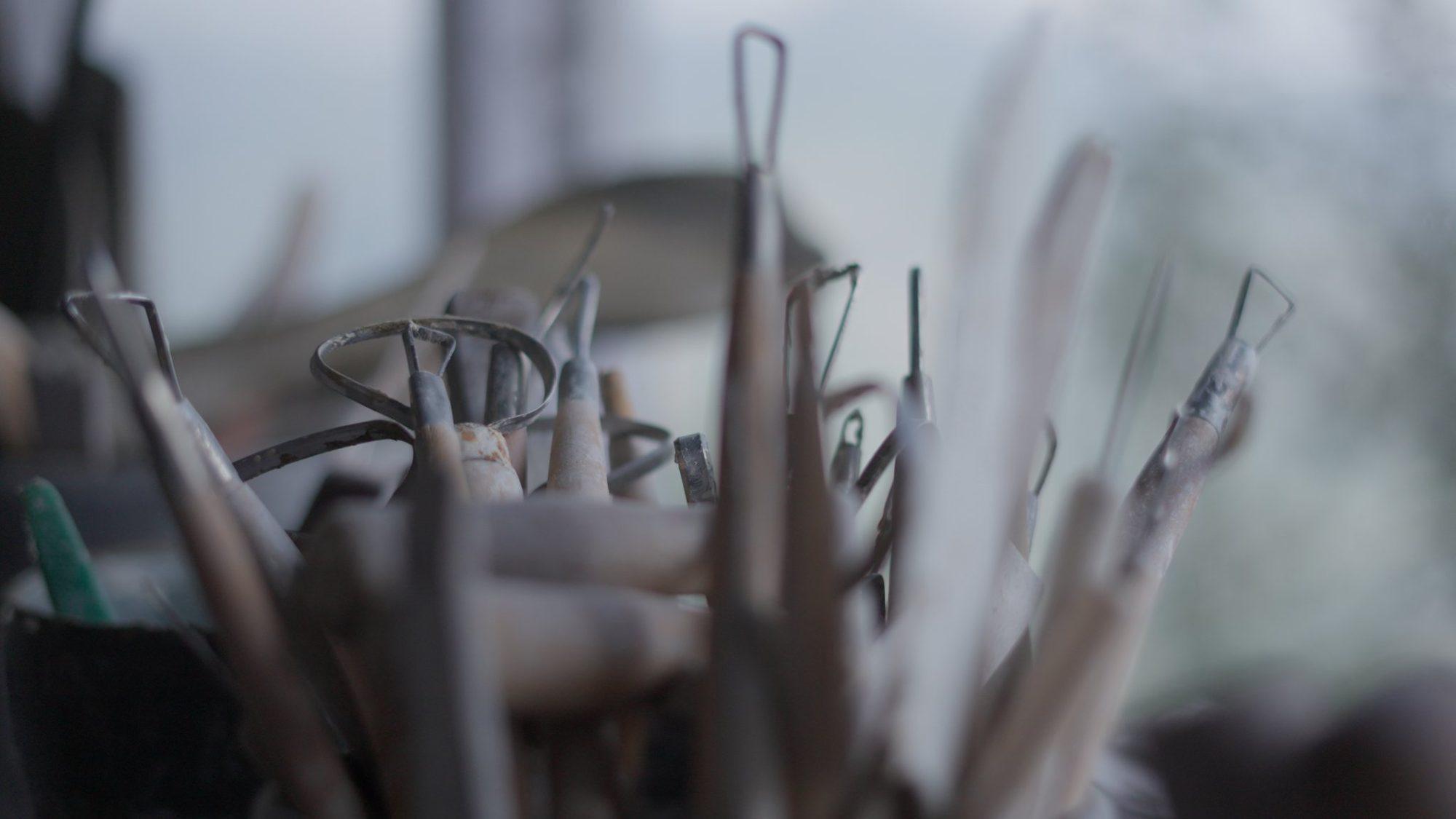 Potter's ribs, loop tools and wires standing ready in a jar