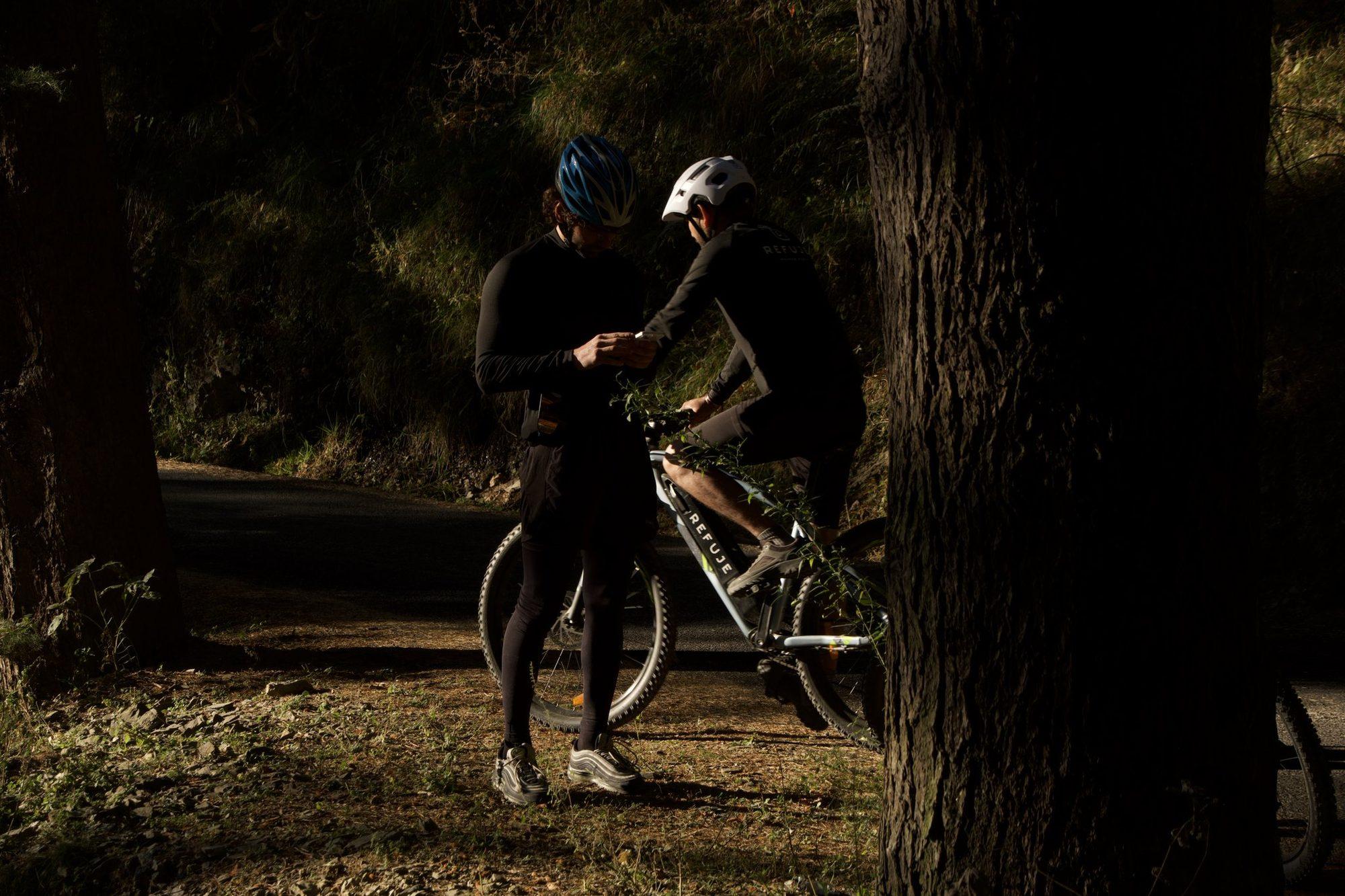 Two riders pausing under the big deodars in low light
