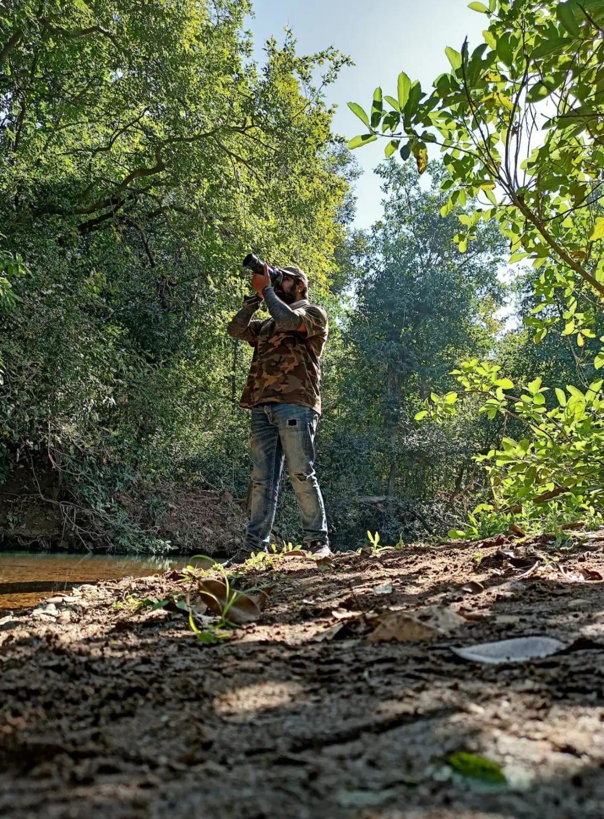 A photographer working from the rock ledge above the water