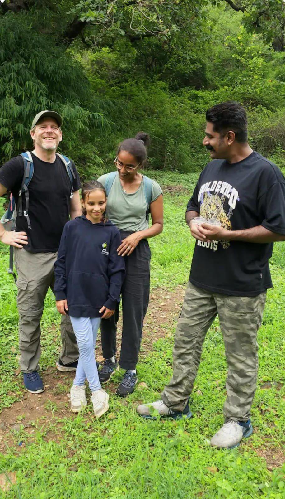A family with their guide in a forest clearing