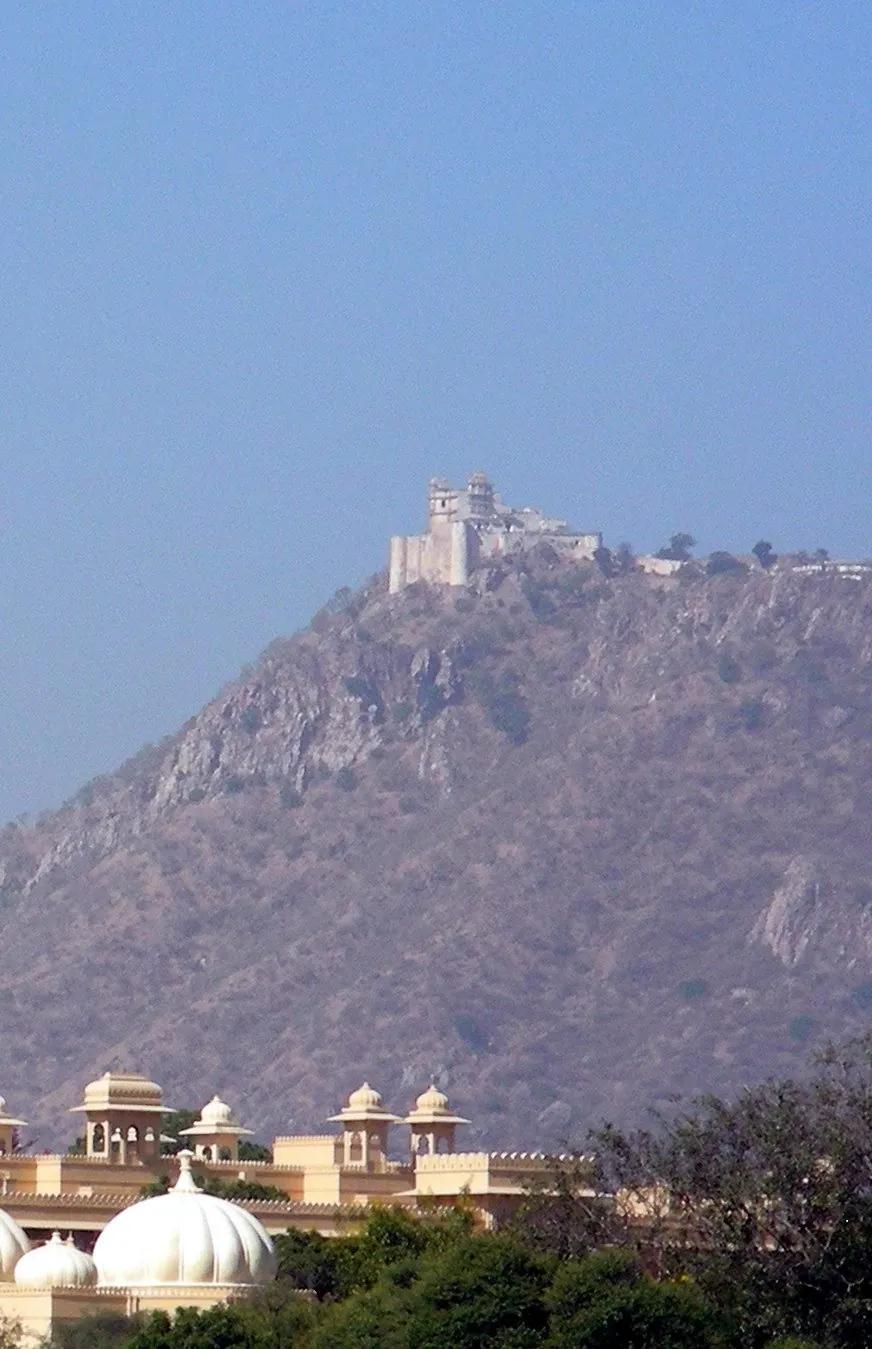 The Sajjangarh Monsoon Palace on a high Aravalli hilltop above Udaipur, with ornate domed pavilions in the foreground