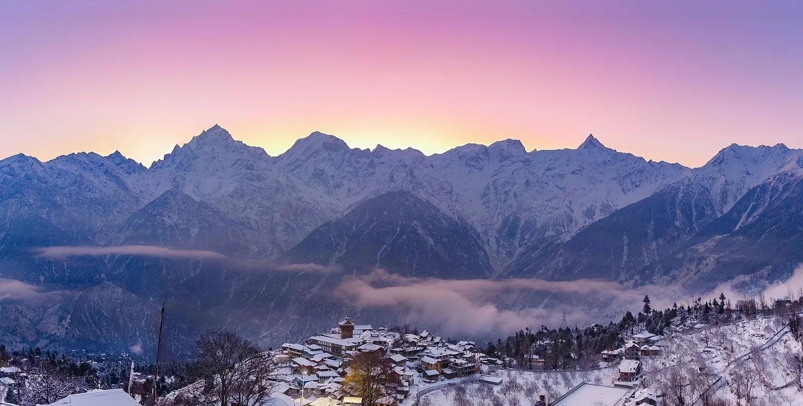 Dusk alpenglow in pink and purple over the snow-covered Kinner Kailash range above Kalpa village, Kinnaur