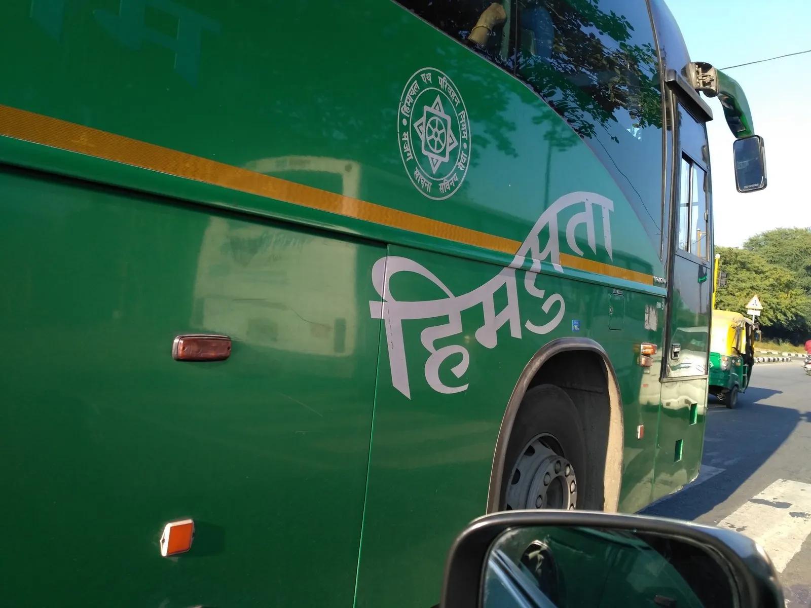 Green HRTC Himsuta Volvo bus side panel with the Himsuta logo in Devanagari and HRTC corporation seal