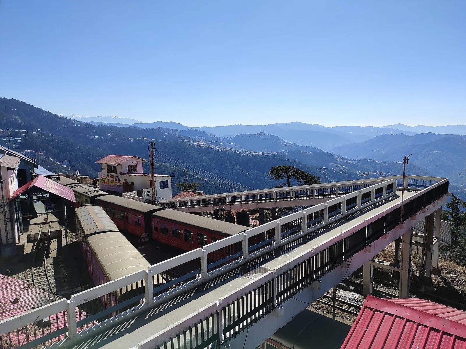 Kalka-Shimla narrow-gauge toy train at Shimla station with Himalayan ridges in the background
