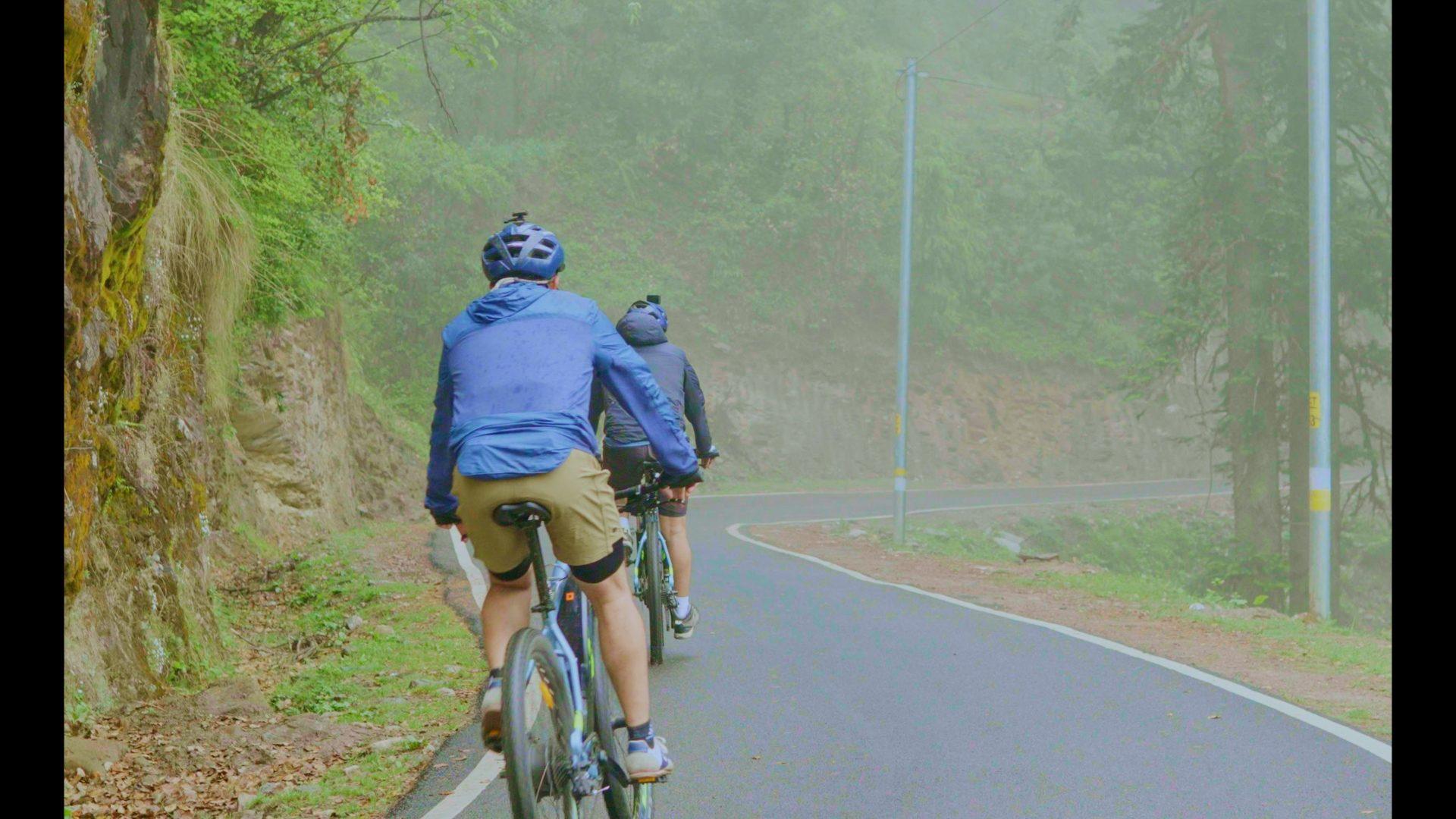 Cyclists on a misty apple-belt road on the Golden Belt route