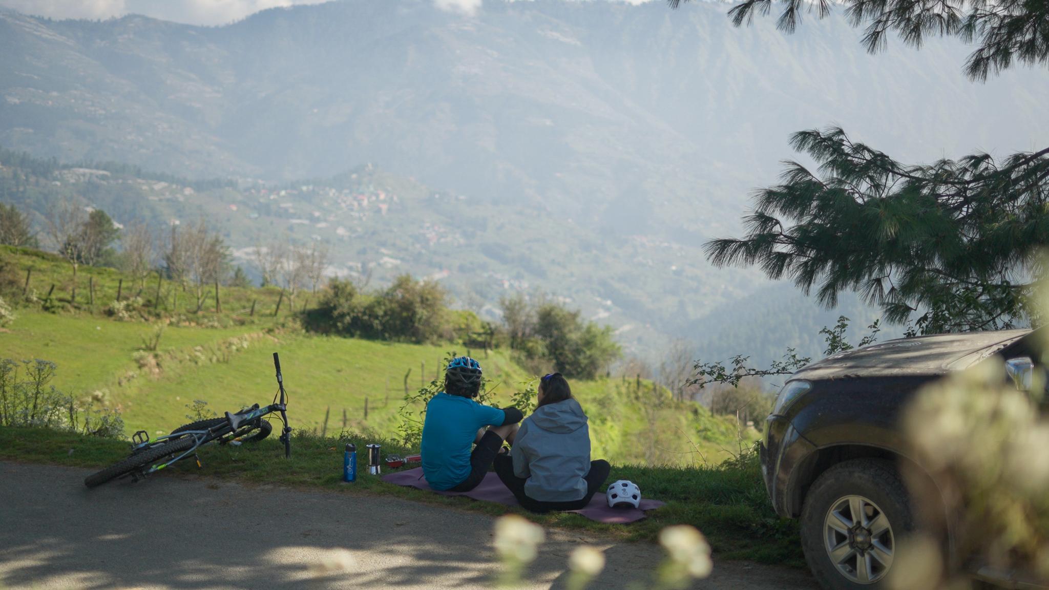 Travellers resting beside the road with a view across the valley