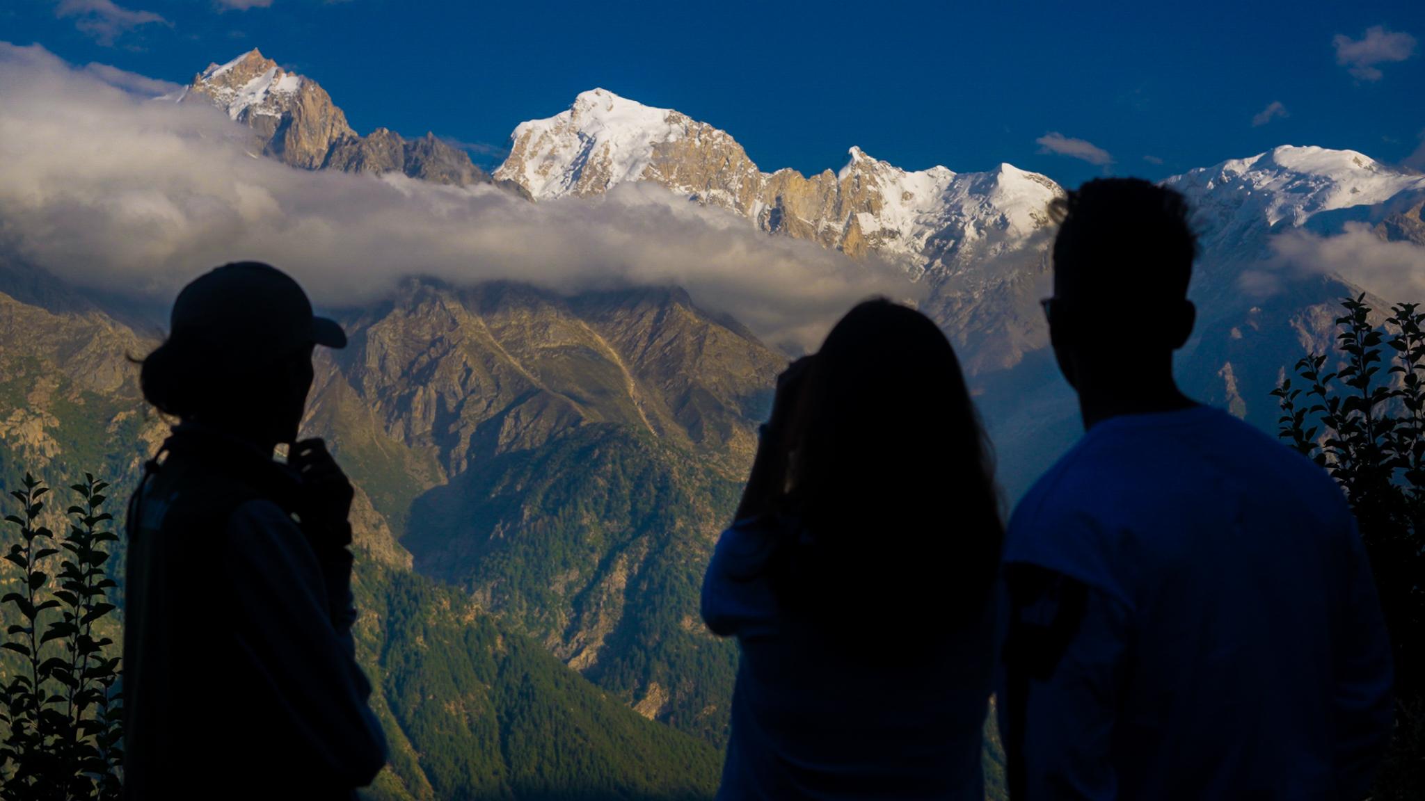 Travellers looking across the valley towards the Himalayan peaks