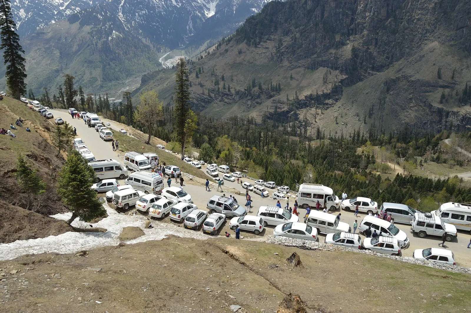 Dozens of white tourist taxis jammed bumper to bumper at Gulaba on the Manali-Rohtang road in peak season, tourists walking between stopped vehicles