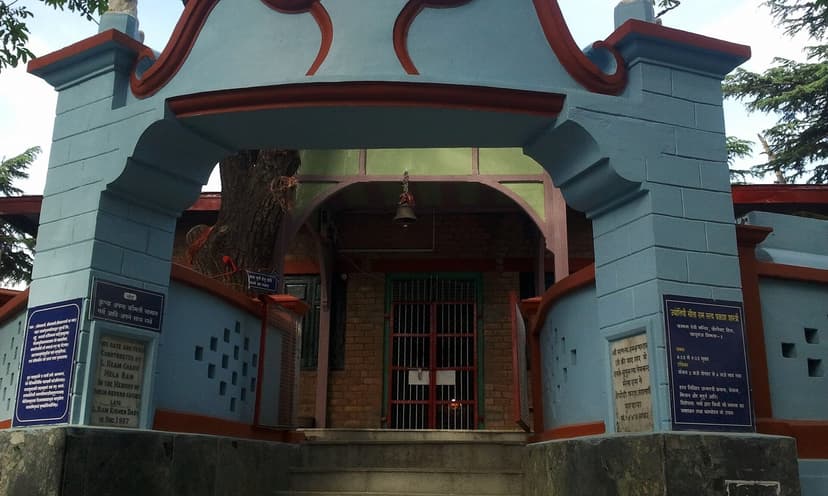Kamna Devi Temple entrance at Prospect Hill Shimla — blue and orange painted temple gate with Hindi signboards, deodar tree behind the structure