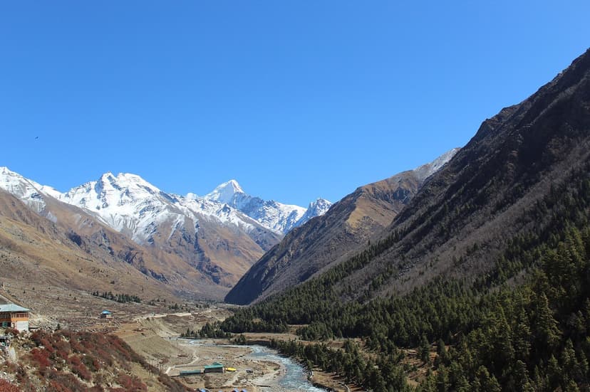 Chitkul village and the Baspa river with snow-capped peaks of the Kinner Kailash range rising behind bare late-autumn slopes