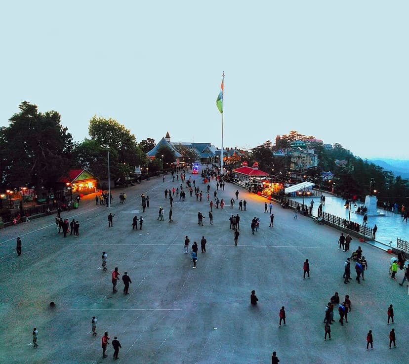 The Ridge at Shimla at dusk, people walking on the open promenade with the Indian flag and Christ Church