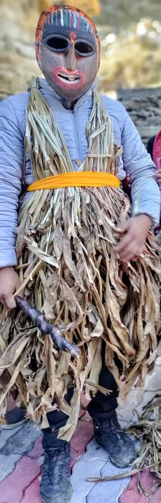 Performer wearing a carved wooden mask and corn-leaf costume during Fagli festival in Kullu district, Himachal Pradesh