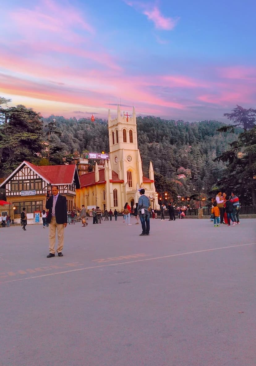 Christ Church on the Ridge in Shimla at sunset with pink sky, colonial architecture, and pedestrians