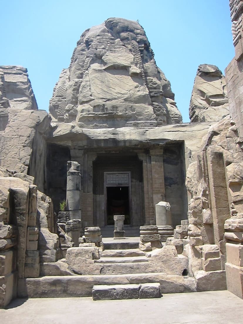 The eroded sandstone shikhara of the central rock-cut shrine at Masrur, carved out of a single monolithic outcrop with stone steps leading up to it