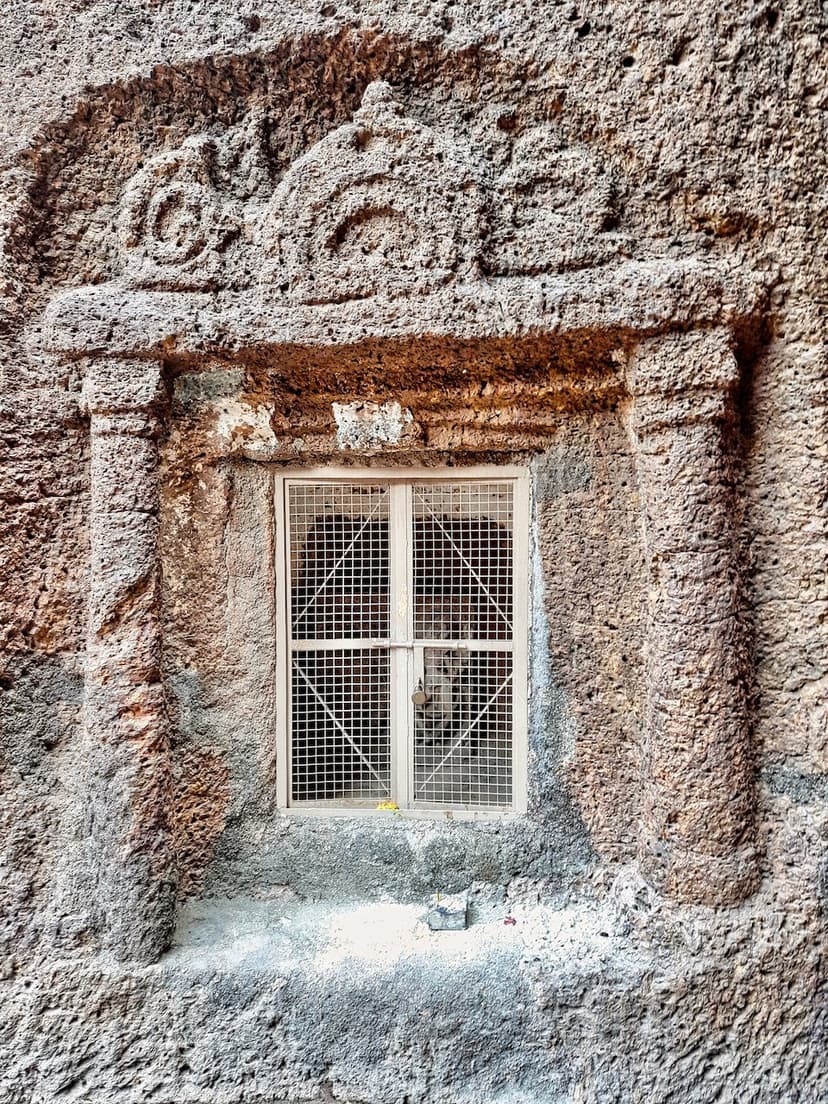 A carved doorway framed in rock-cut stone with a decorative lintel