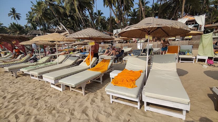 Rows of sunloungers under thatched umbrellas on the sand at Palolem beach