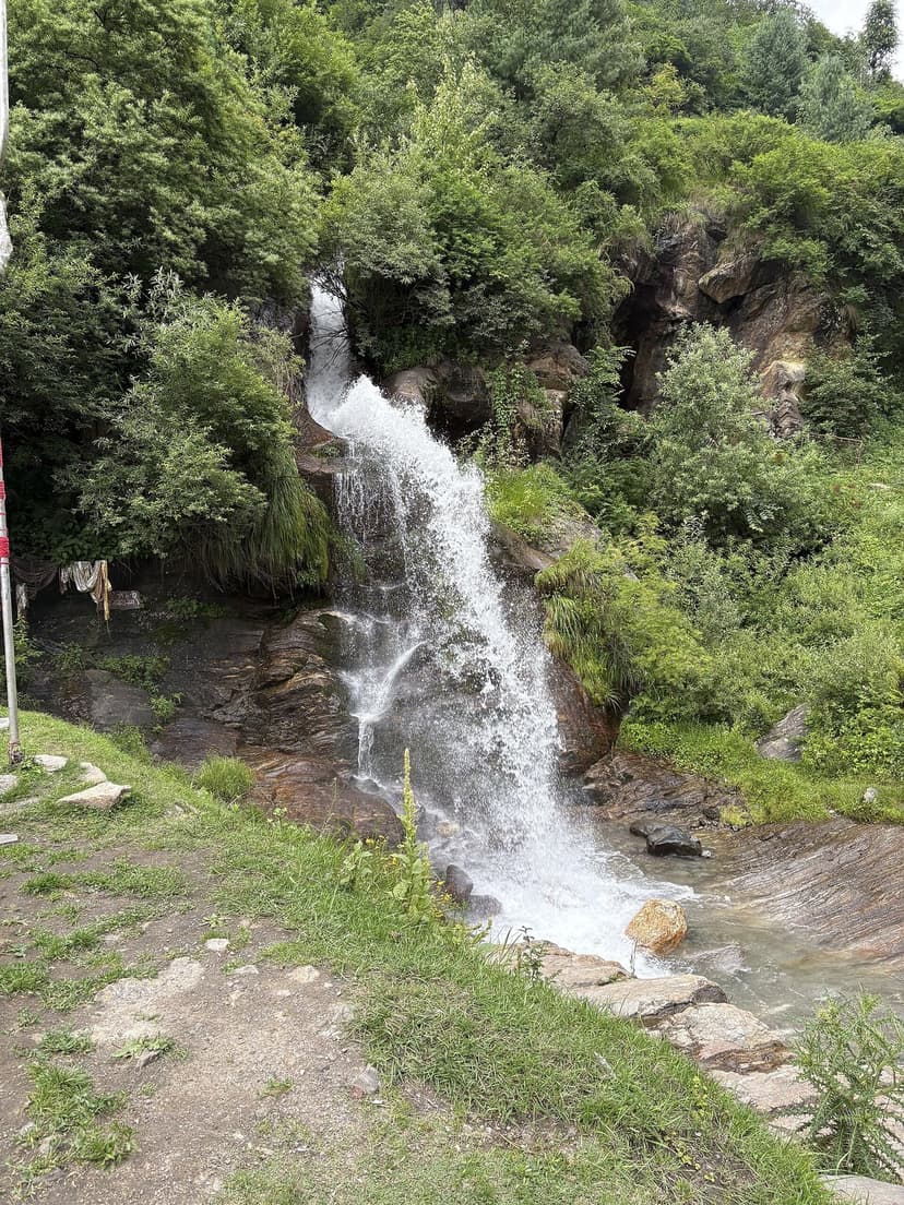 Rudra Nag waterfall on the Kheerganga trail with a small shrine beside it