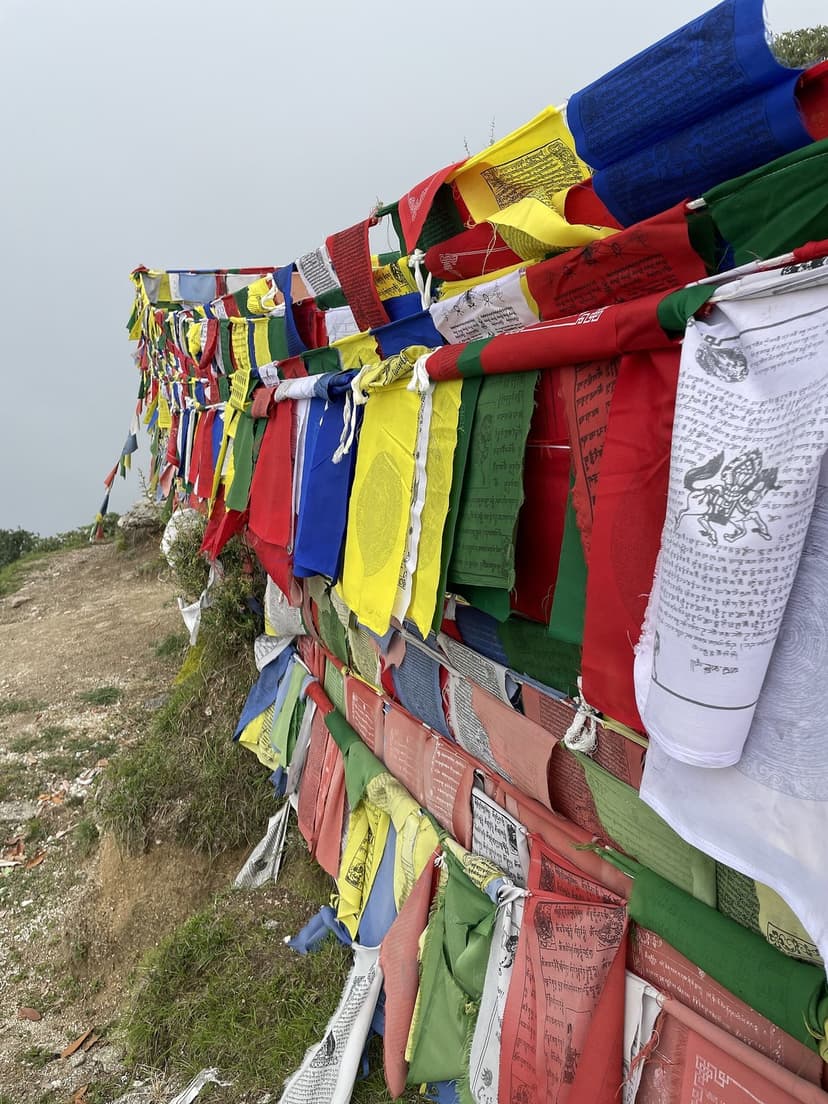 Tibetan prayer flags strung at the edge of the Billing paragliding takeoff site in cloud