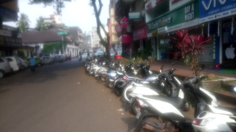 A row of scooters parked for rent on a Panjim street in Goa