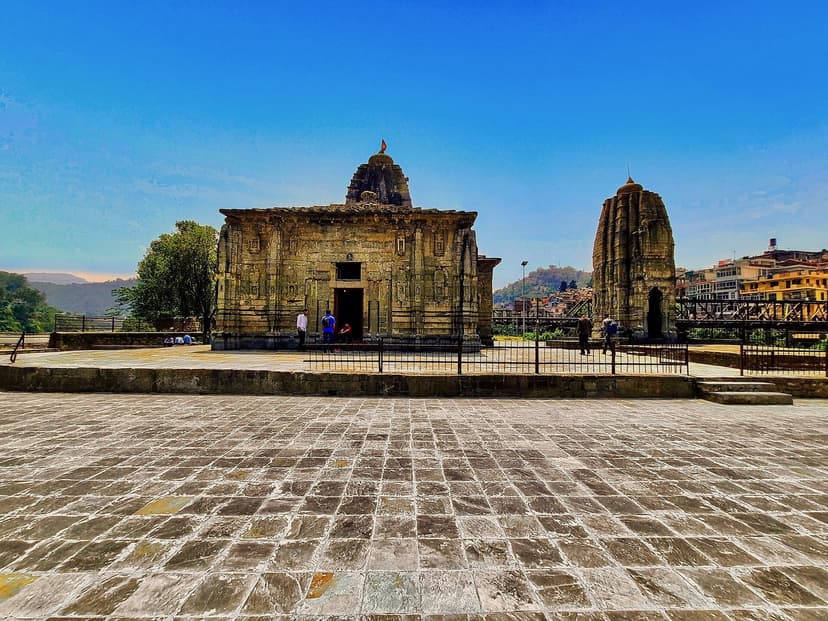 The Pancha Vaktra temple group at Mandi — a stone shikhara temple with smaller subsidiary shrine on a wide paved plaza near the river confluence, the iconic temple complex on the Beas-Suketi confluence