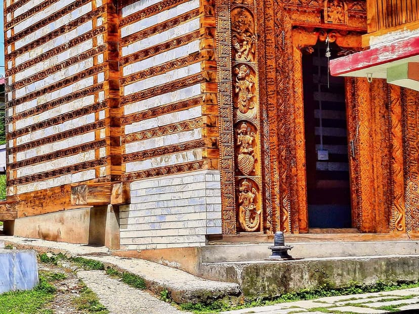 Carved deodar-wood facade of the Shangchul Mahadev temple at Shangarh showing Kathkuni timber and deity panels