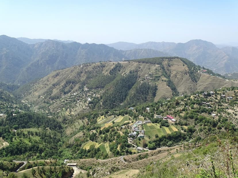 Country road snaking through pine-covered hills with valley villages around Shimla