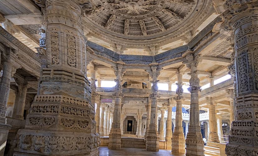Interior of the Ranakpur Jain temple near Udaipur, rows of intricately carved pale marble pillars supporting a domed and sculpted ceiling.