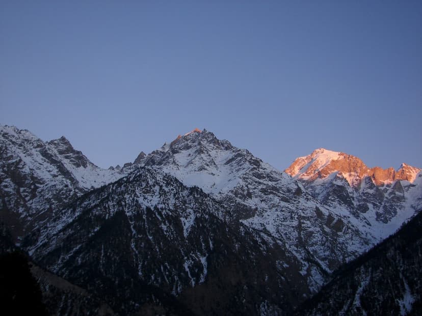 Golden alpenglow on snow-covered Kinnaur peaks at sunset