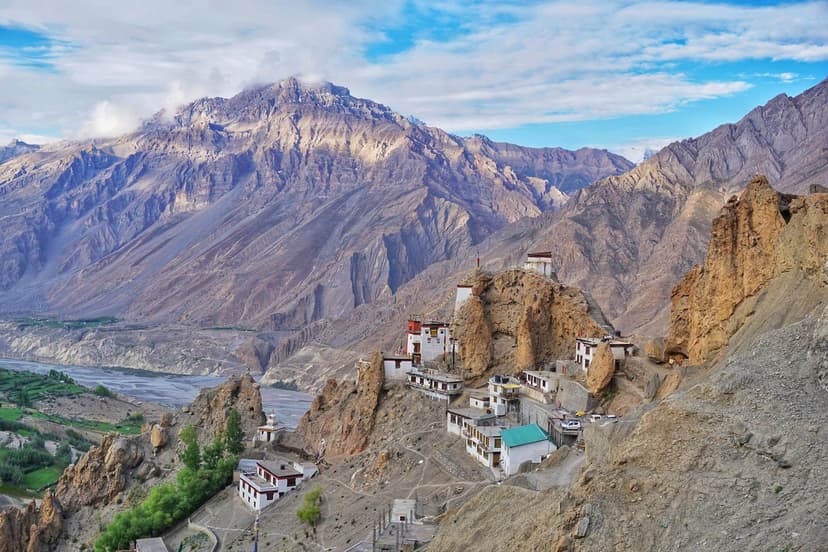 Dhankar Monastery clinging to a sharp rock spur in Spiti, with mountains rising behind and the Spiti–Pin river confluence below