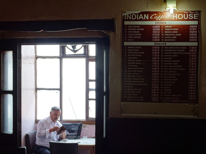 Interior of the Indian Coffee House in Shimla with its old menu board and a man reading by the window