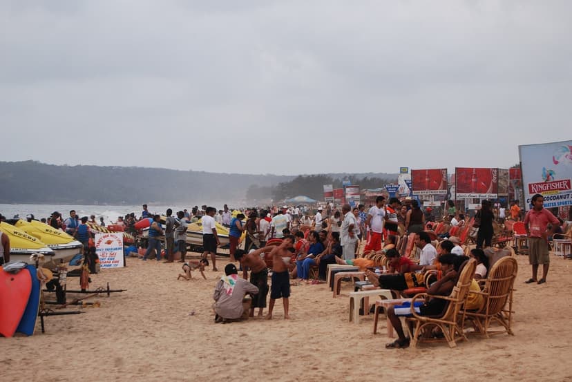 A packed Calangute beach with crowds, sunloungers, jet-skis and shack signboards