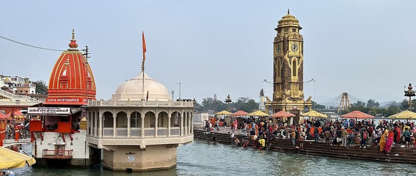 Har Ki Pauri ghat at Haridwar with the golden clock tower, temple domes and pilgrims bathing in the Ganga canal
