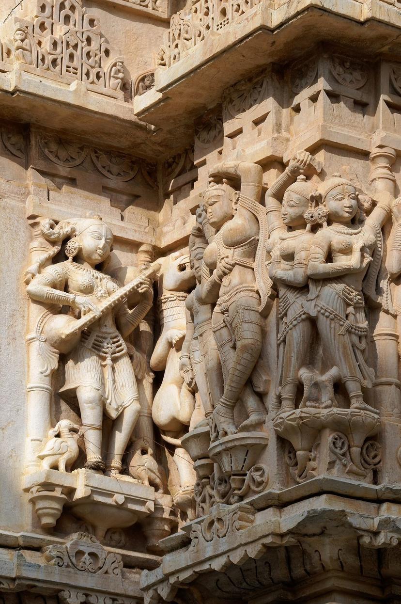 Detailed carved sandstone figures of musicians and dancers on the exterior wall of the 17th-century Jagdish Temple in Udaipur