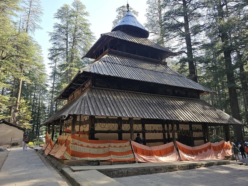 Hidimba Devi Temple at Manali, a four-tiered pagoda in deodar wood with slate roof and prayer flags, in a deodar grove