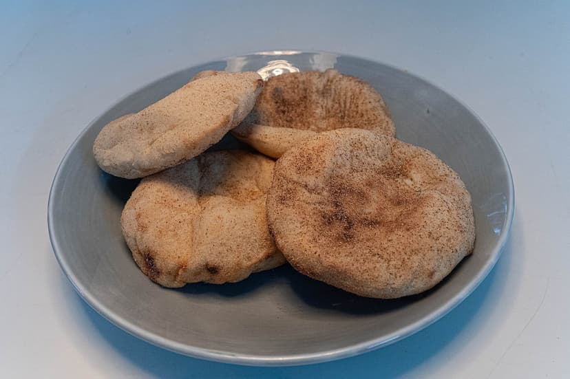 Four round, flat Goan poee breads on a plate