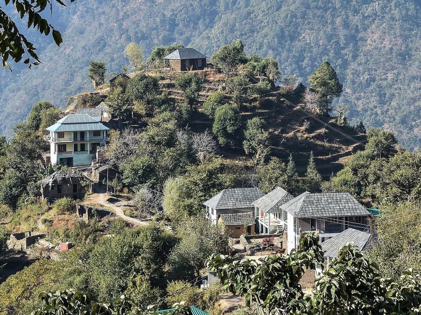 Hillside settlement of Doohaki village in Mandi district, Himachal Pradesh, with wooden and stone houses on a steep ridge and forested slopes with a deep valley behind