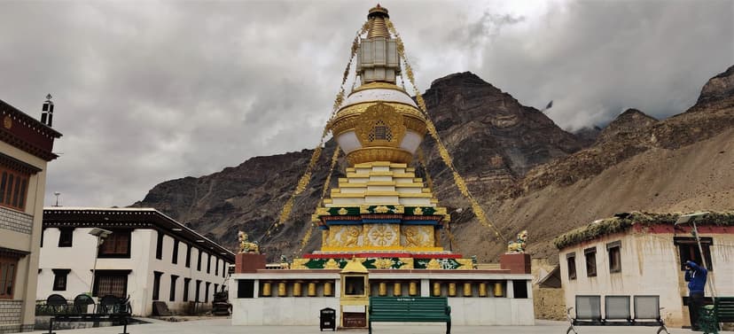 Whitewashed and golden Tabo stupa in Spiti with mountains in the background