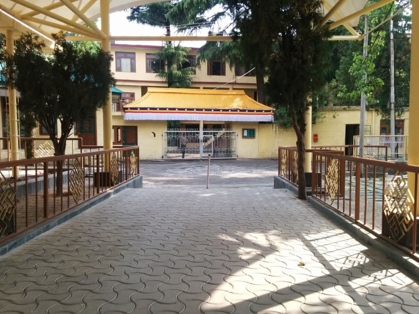 Entrance to the Dalai Lamas residence compound in McLeod Ganj with security gate and Tibetan-style awning