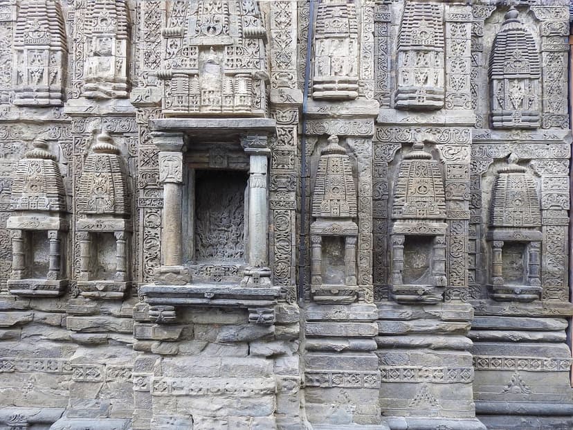 Carved stone wall of Laxmi Narayan temple complex in Chamba with rows of miniature shikhara reliefs and empty niches