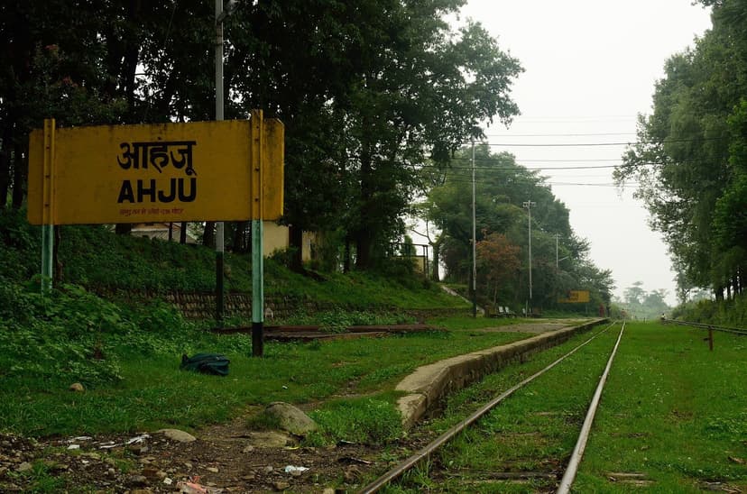 Yellow Ahju station signboard on the Kangra Valley Railway with empty platform