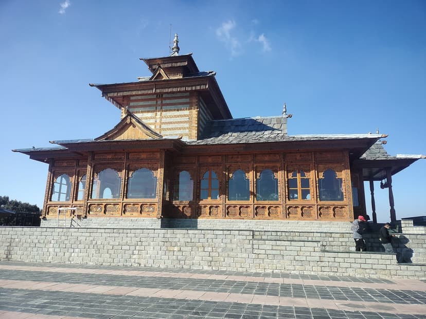 Tara Devi Temple near Shimla — a kath-kuni temple with alternating wood-and-stone walls, carved wooden balcony windows, and steep slate roof at 7,200 feet