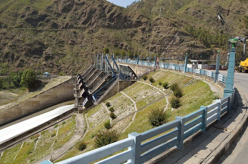 The Pandoh dam spillway on the Beas beside the NH-21 Chandigarh-Manali highway, with a railed roadside in the foreground