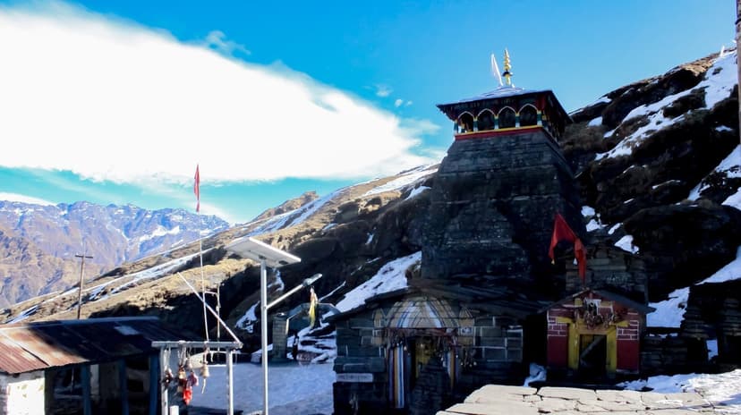 Tungnath temple stone shikhara at 3,680 m with snow patches and Himalayan ridgelines behind, Chopta, Uttarakhand